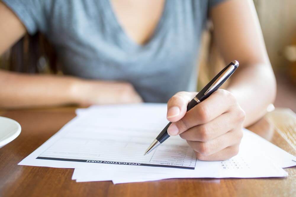 Hand writing on veterinary registration form with pen