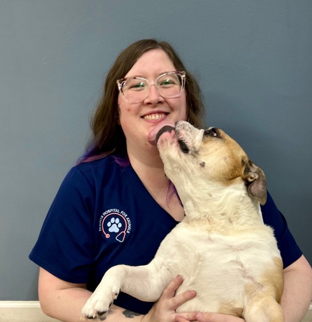 Smiling veterinary technician holding her dog Delilah