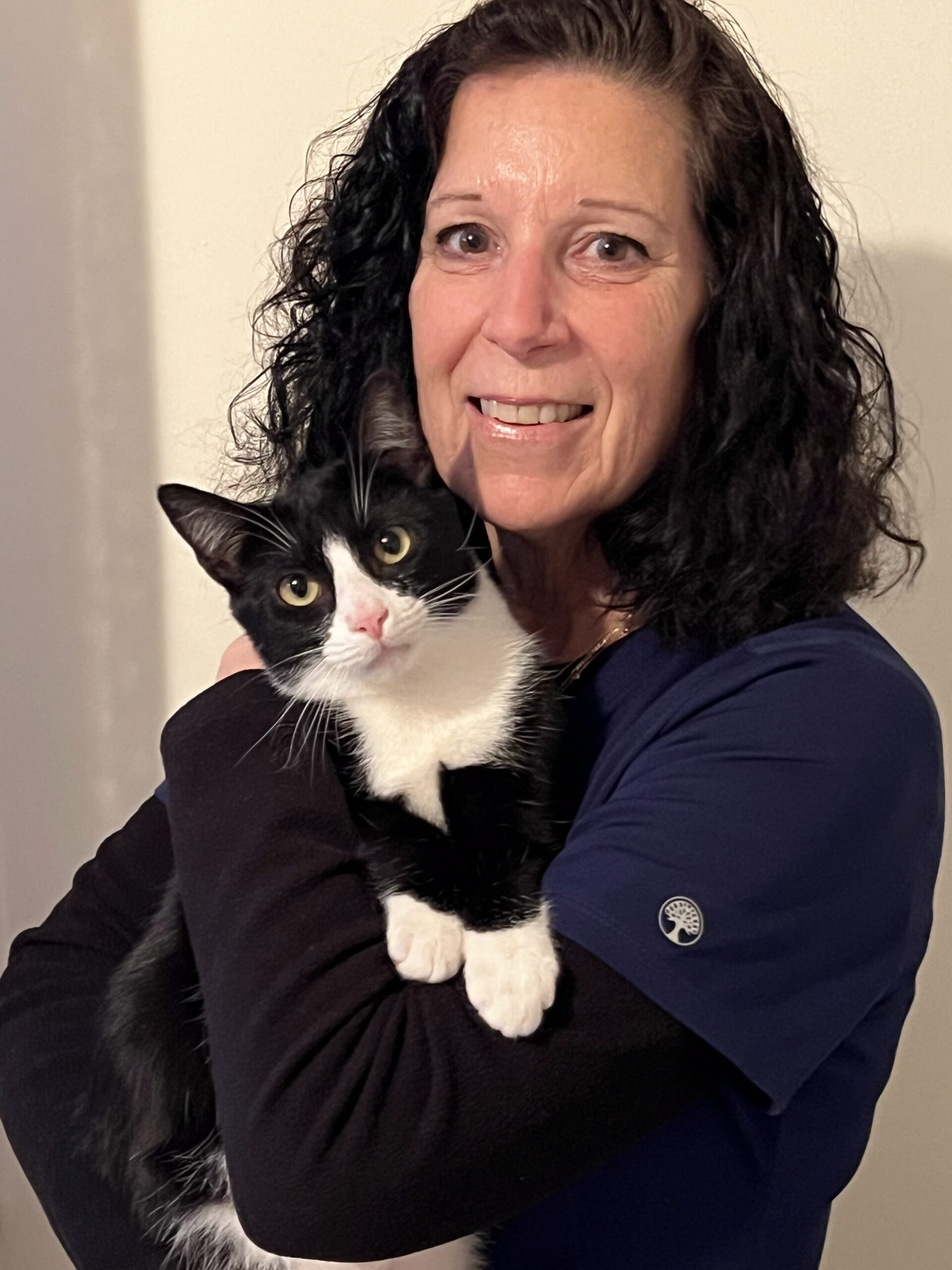 Smiling receptionist holding her black and white cat
